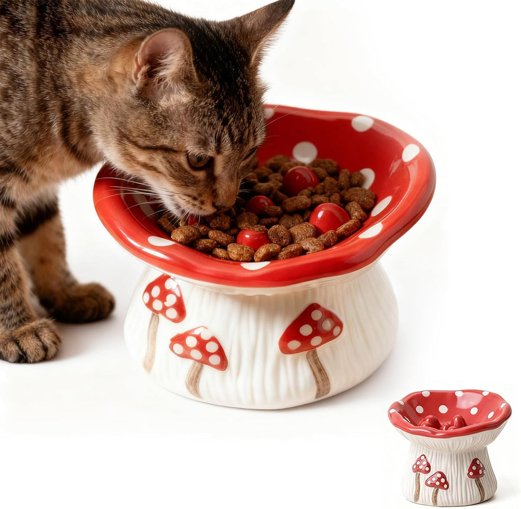 Cat eating from a ceramic mushroom‑design slow feeder bowl with elevated, whisker‑friendly shape and non‑slip base.