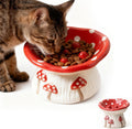 Cat eating from a ceramic mushroom‑design slow feeder bowl with elevated, whisker‑friendly shape and non‑slip base.