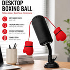  Desktop boxing ball toy on a desk with flexible stem, strong suction base, and red punching gloves for stress relief and focus.
