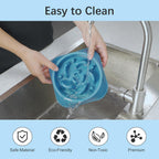 Person washing a blue slow feeder dog bowl with maze design under running water, highlighting easy cleaning, safe material, eco‑friendly and non‑toxic features.
